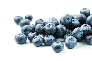 Tasty blueberries fruit are scattered on a white background.