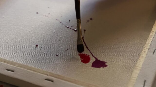Anonymous artist creating with watercolor and a straw