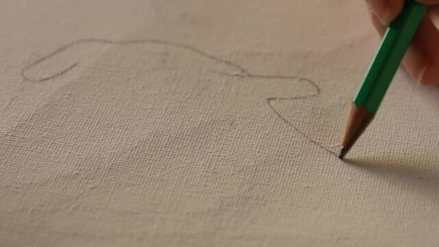 Anonymous artist drawing silhouette into canvas with a pencil