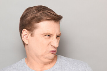 Obraz premium Portrait of funny man grimacing from disgust and squeamishness