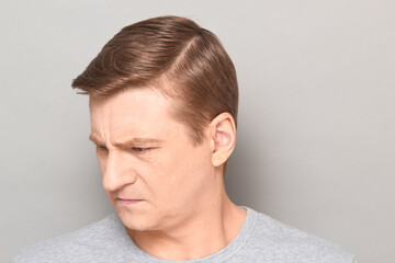 Portrait of angry disgruntled mature man with frowning face