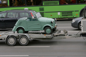 little funny old car that is carried on the trailer.