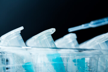 microbiological pipette in the genetic laboratory. study of a virus or vaccination. blue tinted.