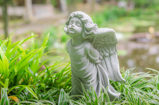 Figurine of  a little  angel cupid  in the garden.