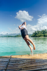 Tourist  jumping into the lake from the raft. Adventure trips on summer holidays. Outdoor activity...