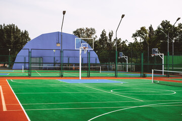 Outdoor sports field with artificial turf
for playing tennis and basketball.