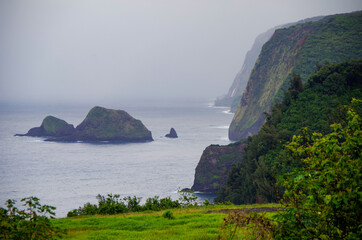 View from lookout over Pololu Valley coast line on misty or foggy day on Big Island in Hawaii with...