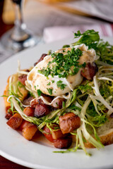 Salad. Frisee lettuce dress with olive oil and balsamic vinegar and topped with bacon lardons a fried egg and garnished with italian parsely and a toasted baguette. Served in a French Bistro.