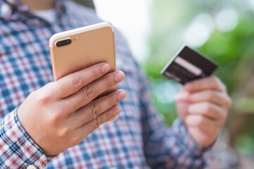 Online shopping.man holding a credit card and using smartphone.