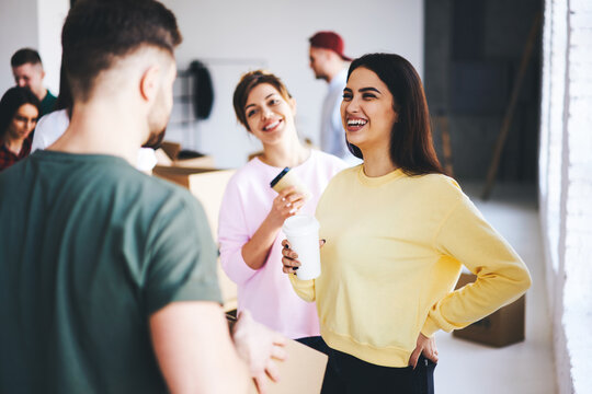 Charming attractive female hipsters talking with male coworker joking and having fun while making preparation for designing office indoor collaborating and helping each other in friendly atmosphere - Powered by Adobe