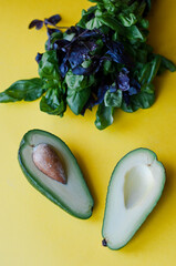 Fresh lettuce, avocado in a small pot. Green leaves on a yellow background. Flat lay. Eco food. Place for text