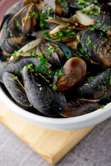 Mussels. Classic French or American restaurant appetizer: steamed mussels. Shellfish steamed with white wine, butter, garlic, onions and fresh herbs. Served with butter toasted baguettes.