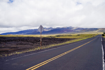 Country road through lava field in Mauna Kea State Park in Halepohaku area on Big Island in Hawaii...