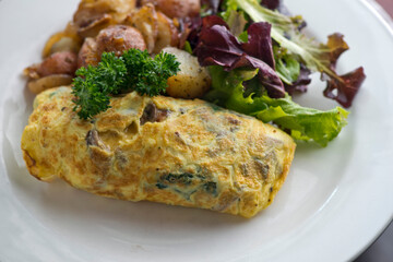 Omelette made with bacon, ham, sausage, bell peppers, heirloom tomatoes, spinach, onions, cheddar & Swiss cheese. Served with crispy potato hash, a classic American breakfast or brunch favorite.