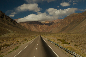 Transport. Traveling along the desert highway. Asphalt straight road into the arid mountains and valley. 