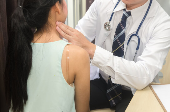 Medical doctor is examining glands in the neck of his patient.