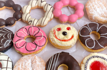 smiling face donut  amidst Colorful donuts on white background,Different thinking, positive thinking concept.