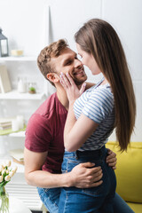 smiling romantic young couple hugging at home