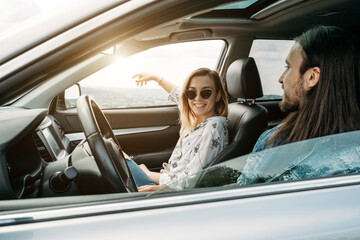 Young Stylish Traveling Hipsters Having Fun Sitting in Modern Car, Travel and Road Trip Concept