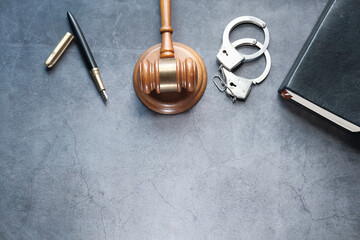  gavel, book and handcuff on black background top down 