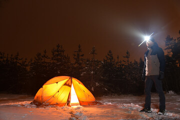 hiker is stand near tent in night winter forest © Oleksandr
