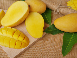 Half sliced mangoes on a cutting board