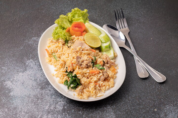 Pork fried rice on a white plate on a black background
