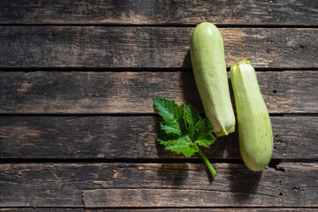 Zucchini fruit on wooden garden table background.