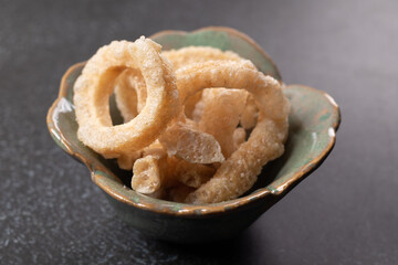 pork rind in a cup on a black background. Thai food