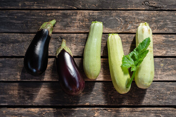 Ripe eggplant and zucchini fruits on the garden table flat lay background.