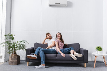 Fototapeta premium pozytywna dziewczyna i chłopak przytulanie się w domu z klimatyzatorem