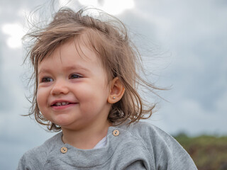 Little girl on a windy day, looking around