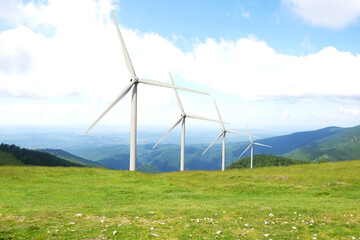 Fototapeta na wymiar Alternative energy source. Wind turbines in mountains under cloudy sky