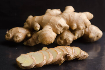 Fresh organic ginger on black stone background