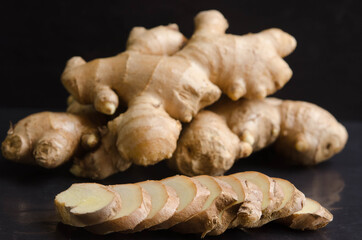 Fresh organic ginger on black stone background