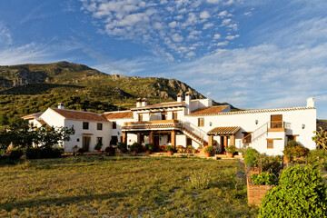 Whitewashed country house with courtyard in the Spanish countryside , Finca Cortijo Las Monjas,Malaga,Andalusia, Spain.Blue sky warm evening at sunset