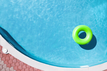 Fototapeta na wymiar Inflatable ring floating in swimming pool, top view with space for text. Summer vacation
