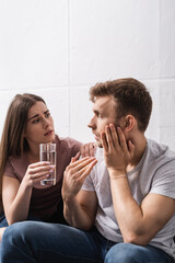 sad couple with glass of water at home during summer heat