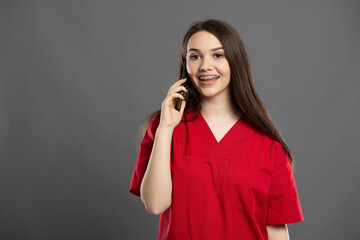 Attractive nurse with braces talking on her mobile phone to a patient