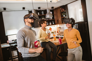 Happy black family at home. Dad, mom and daughter playing virtual reality.