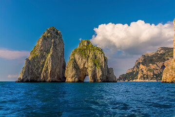 Cumulus clouds hover over the Faraglioni rocks on the eastern side of the Island of Capri, Italy