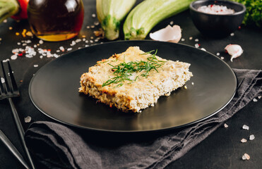 Zucchini casserole on dark background. Dietary, low-calorie, healthy food. Homemade Casserole from squash with chicken and eggs. Selective focus