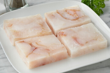 Dish with frozen cod fish fillets to thaw