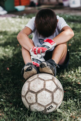 boy playing soccer with torn shoes