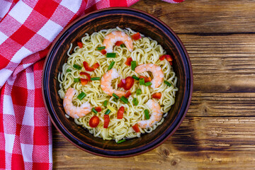 Instant noodle with shrimps, red pepper and green onion in a ceramic bowl. Japanese food. Top view