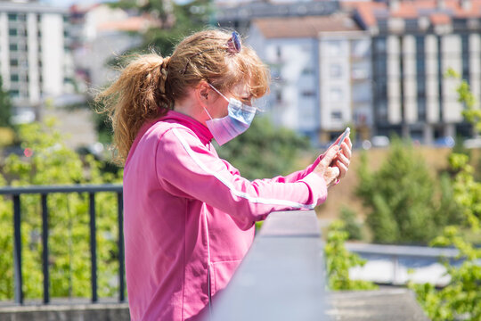 woman with medical mask and sports clothes on the street using the mobile phone to prevent viruses and infections