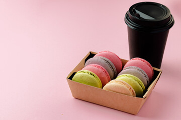 Pile of colorful macaroon cookies on pink background