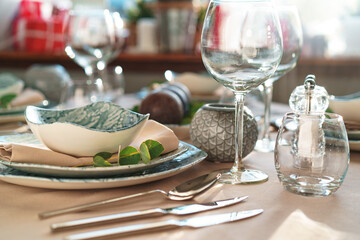 Beautiful elegant table setting with green stylish dishware and silver cutlery