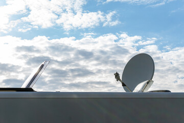 close up view of a recreational vehicle with an open roof hatch and a satellite dish