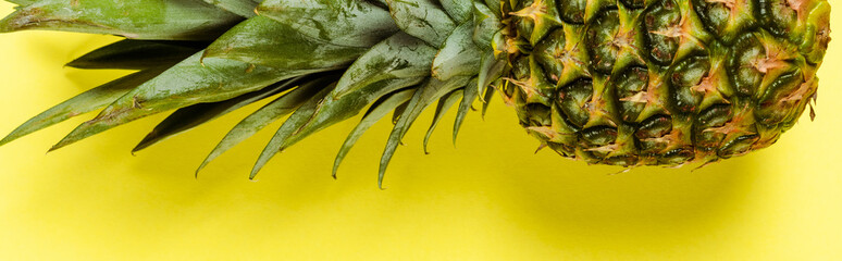 Top view of ripe pineapple on yellow background, panoramic shot